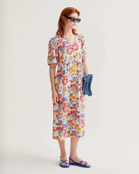 Woman wearing a colorful floral dress on a white background